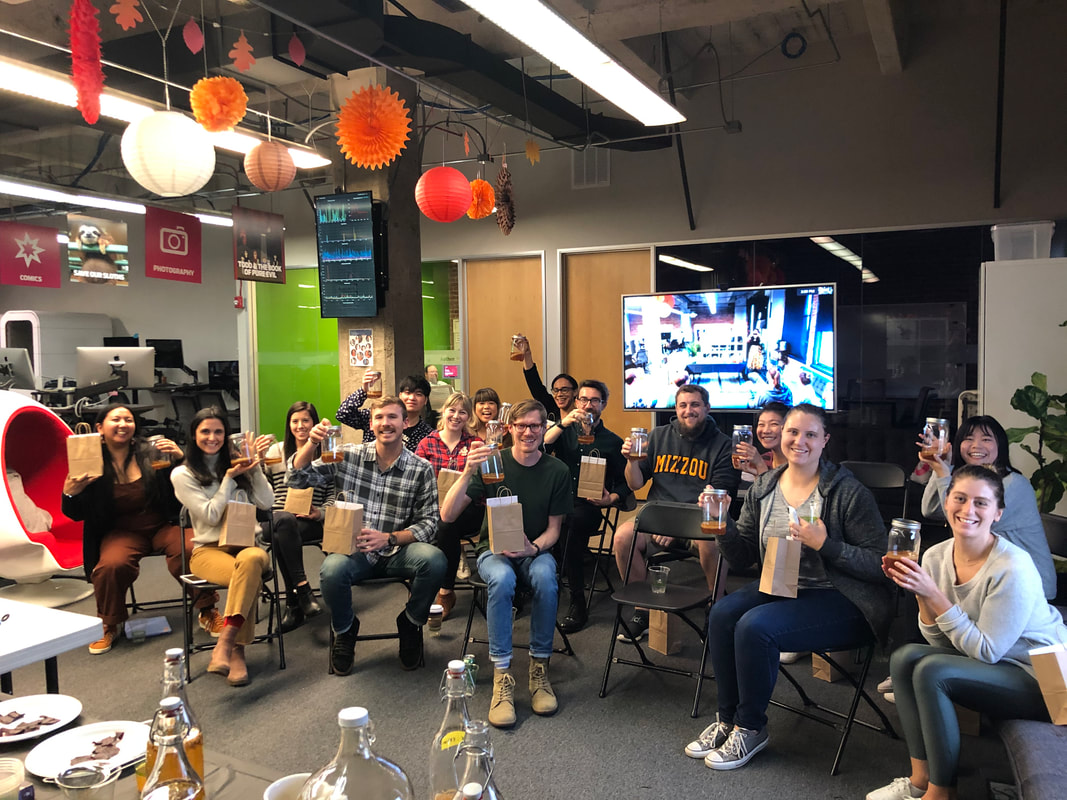 Group of people holding kombucha scoby in jars attending a corporate kombucha class