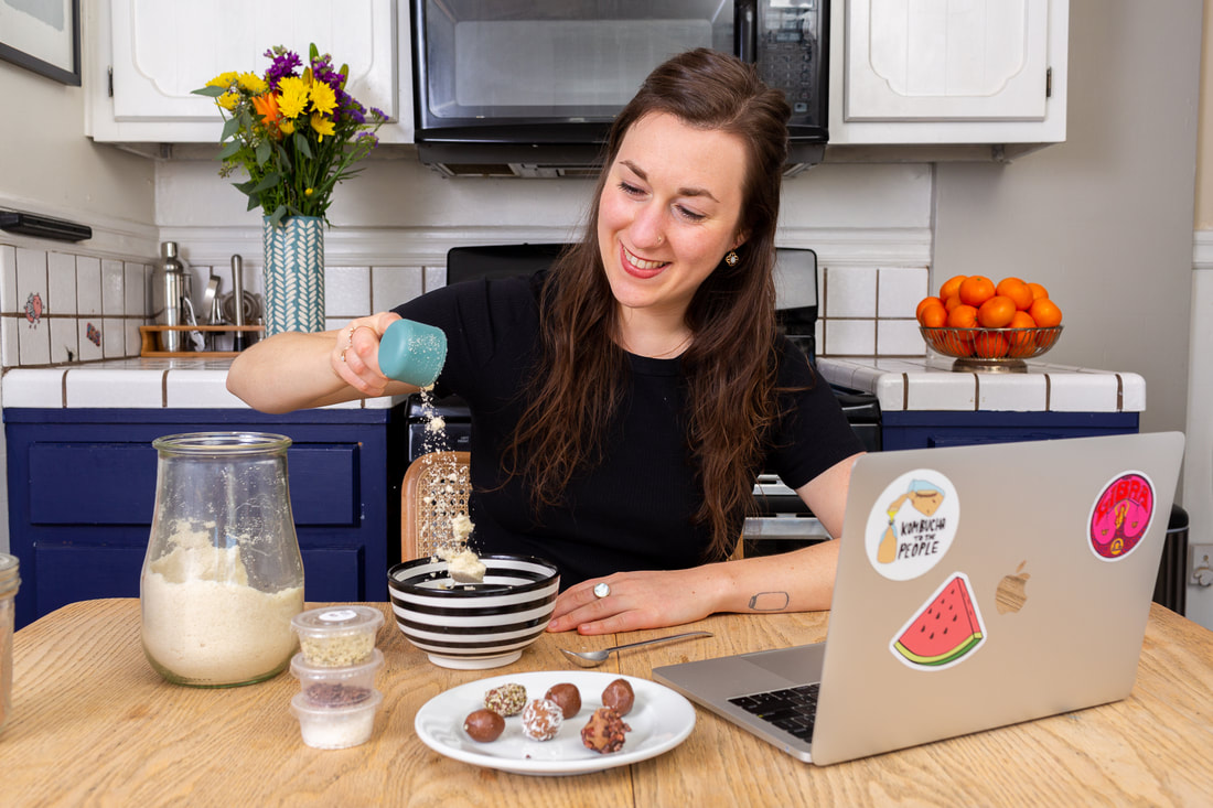 Woman teaching Hack Your Snacks virtual corporate workshop in kitchen pouring almond flour into bowl