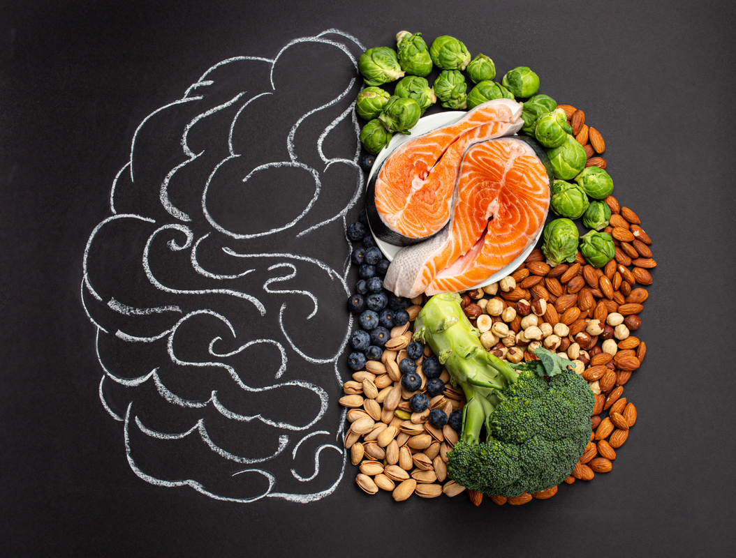 drawing of brain with brain boosting food covering one half including broccoli, nuts, blueberries, salmon and brussle sprouts