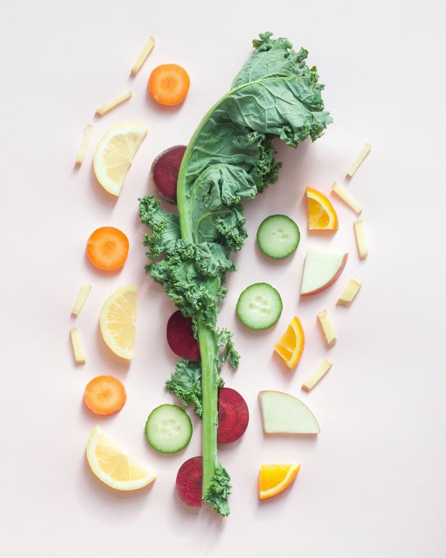 leaf of kale with fruits and vegetables on pink background