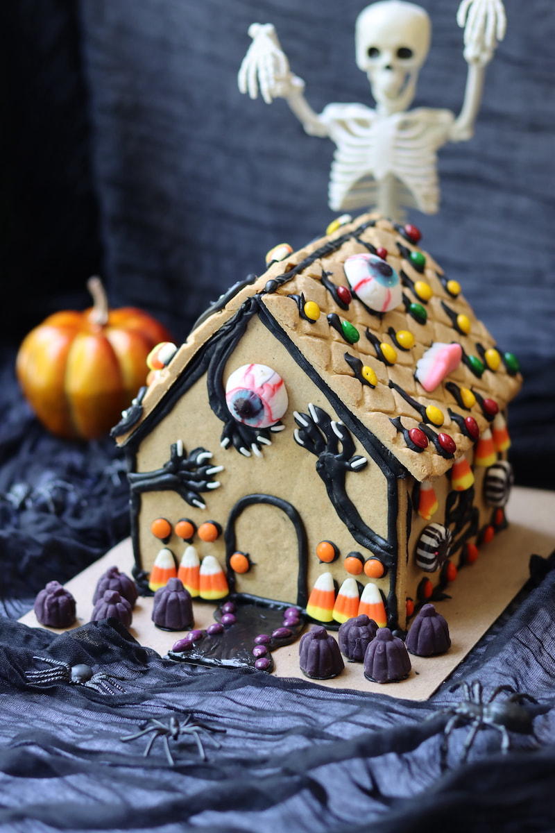 Gingerbread Haunted House with black icing and colorful candies for corporate team building class.