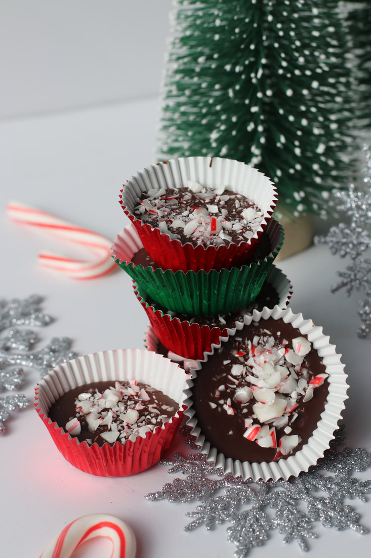 Chocolate peppermint bark bites with crushed candy canes on top in red and green foil.