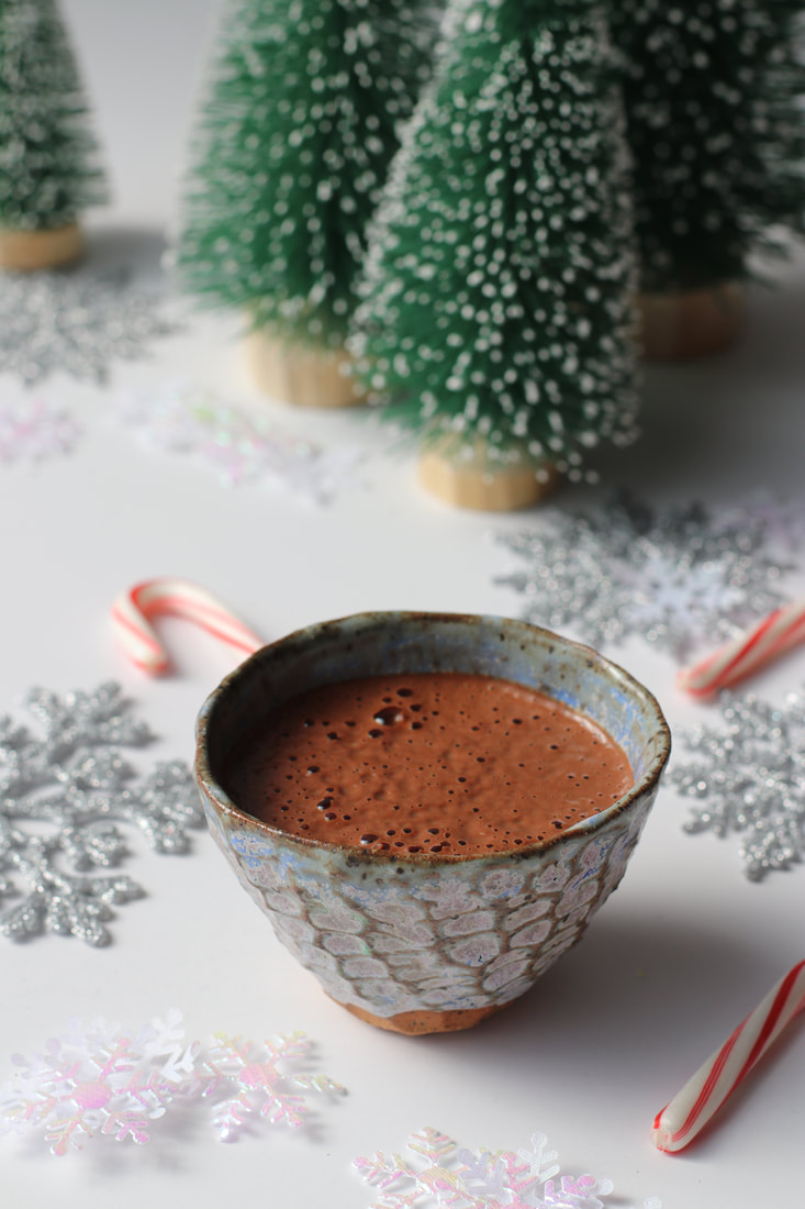 Chocolate elixir with chocolate and holiday decor in the background