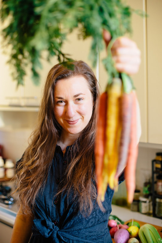 Person holding up a bunch of carrots not in focus