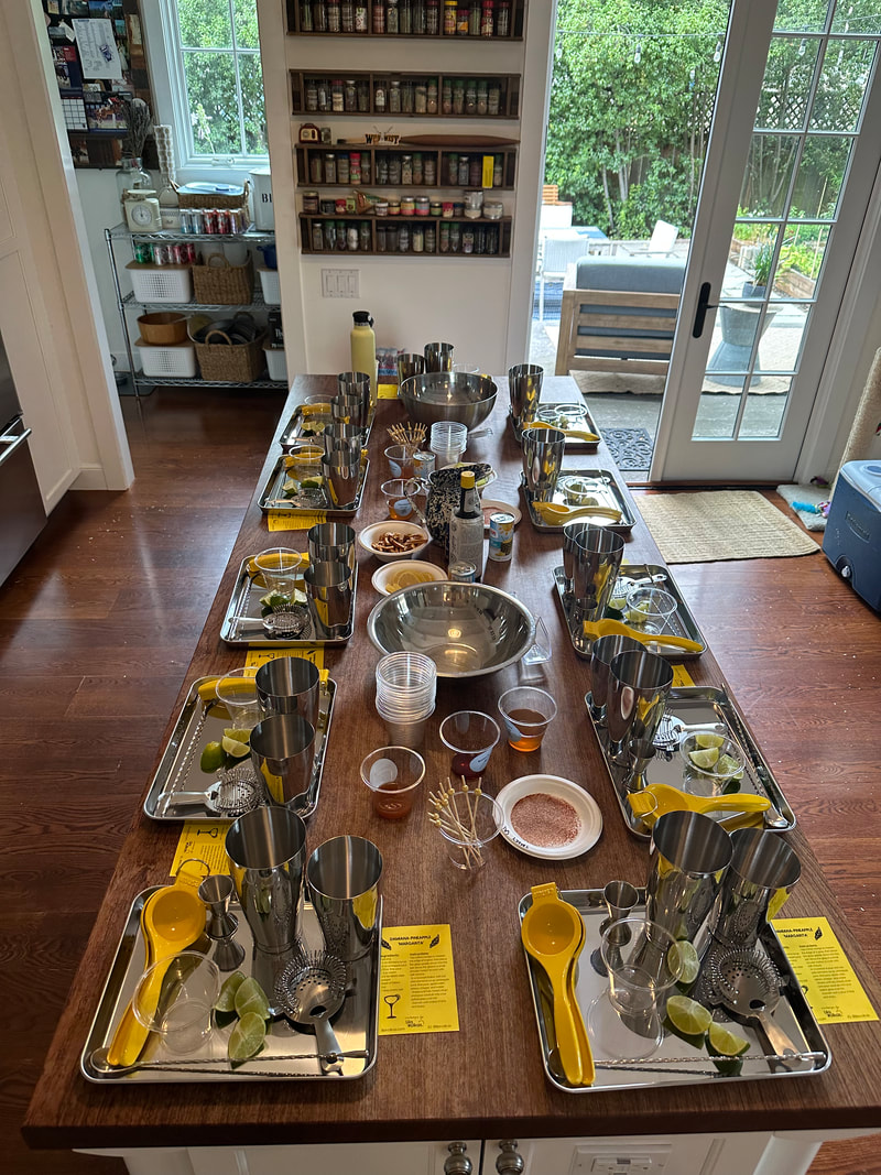 Mocktail mixology workshop with 12 stations of barware on trays at a private home