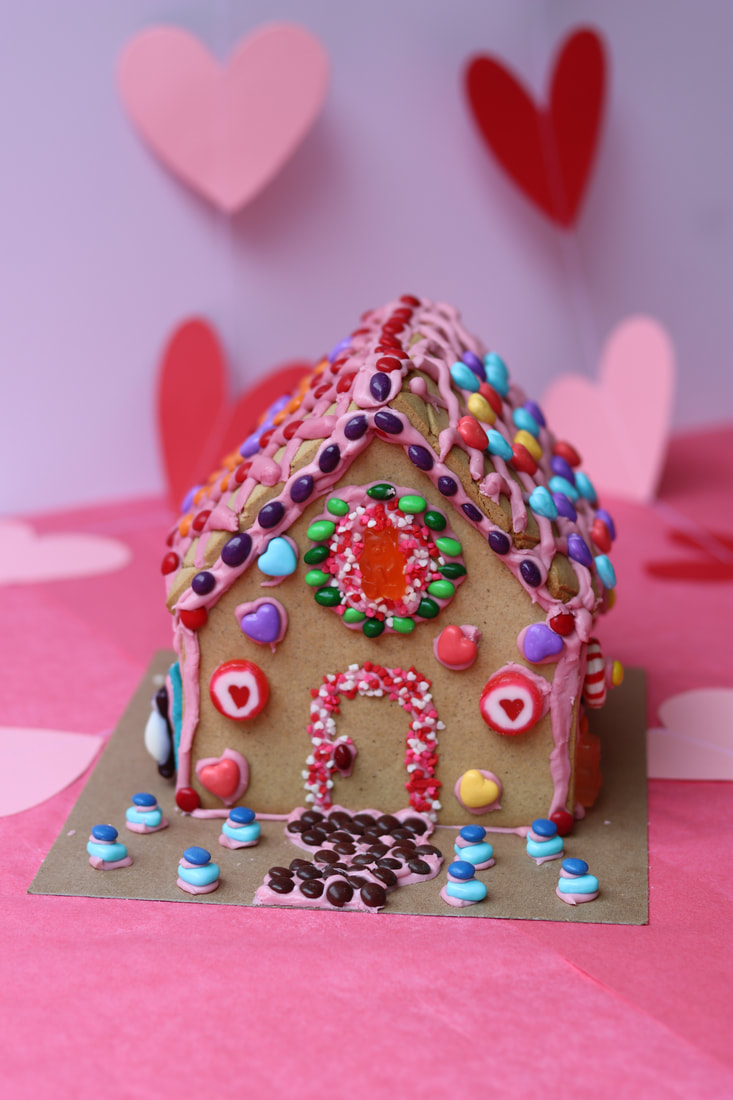 Gingerbread Love Shack with colorful candies and pink background from virtual valentine's corporate team building class.